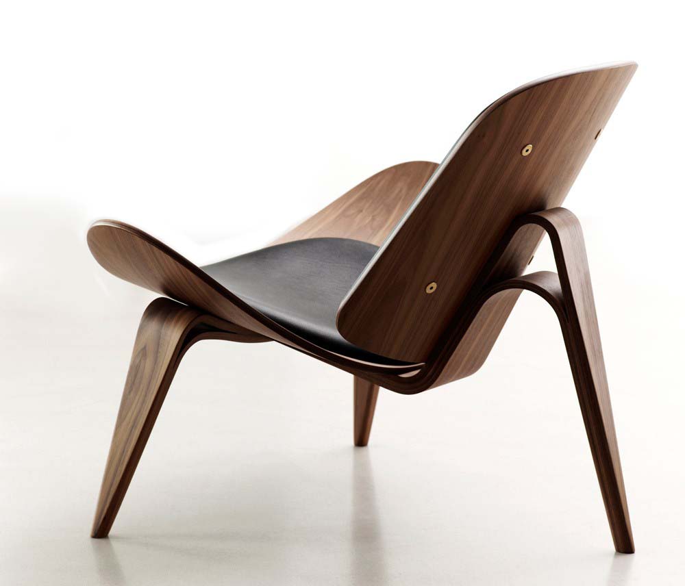 Um clássico do design, a poltrona Shell foi criada em 1963 por Hans Wegner, designer dinamarquês que tinha como base de sua atuação a aplicação da madeira em curvas. Profissional experiente e inovador, Wegner acreditava que “uma cadeira deveria ser bonita de todos os lados e ângulos”, conceito que fez surgir a poltrona Shell, com seu efeito surpreendente e leve causado pela “funcionalidade orgânica” aplicada na forma como o designer criava suas peças. 